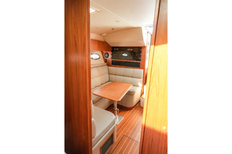 Slide: The Image of Interior of 1999 Tiara Yachts 3500 Open with beige seating and wooden table. - 12