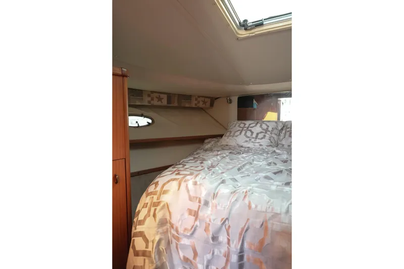 Slide: The Image of Cozy cabin interior of 1999 Tiara Yachts 3500 Open with patterned bedding. - 13