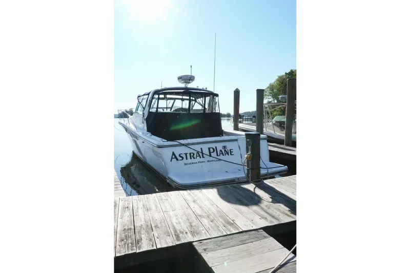 Slide: The Image of 1999 Tiara Yachts 3500 Open docked, featuring blue canopy and sleek design. - 2
