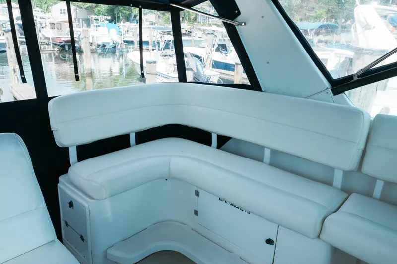 Slide: The Image of Interior seating of 1999 Tiara Yachts 3500 Open, featuring white cushioned benches. - 8