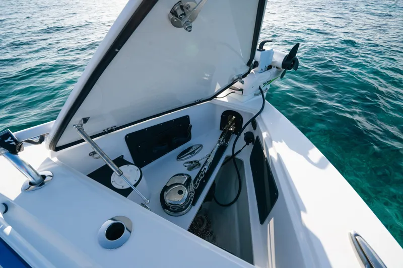Slide: The Image of 2022 Nor-Tech 392 Super Fish boat anchor compartment with open lid, on clear blue water. - 36