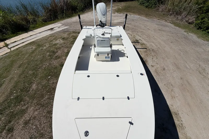 Slide: The Image of 2026 Hewes Redfisher 21 boat on grassy terrain, showcasing sleek design and spacious deck. - 10