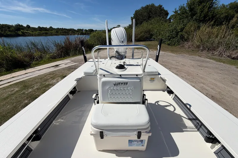 Slide: The Image of 2026 Hewes Redfisher 21 boat near a scenic lake, showcasing seating and console. - 11