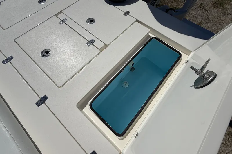Slide: The Image of 2026 Hewes Redfisher 21 boat deck with storage compartments and open hatch. - 16