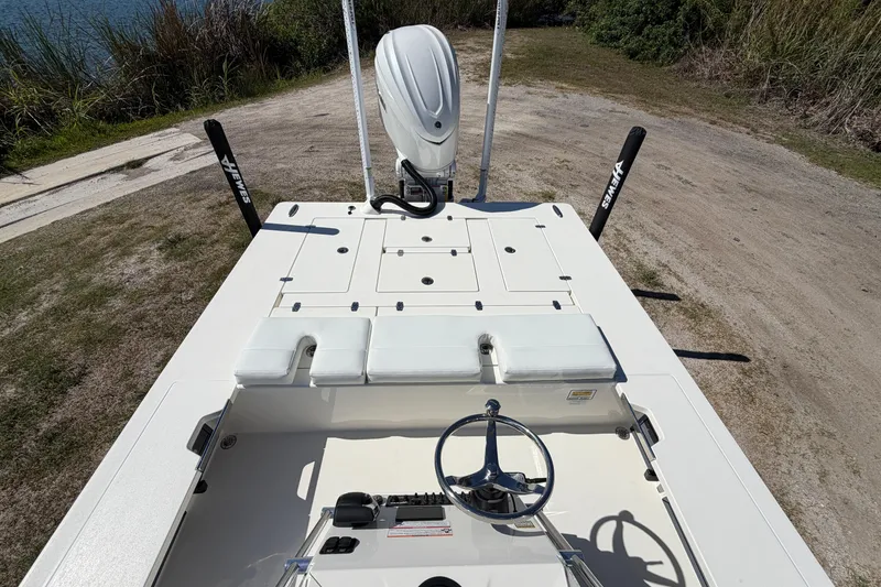 Slide: The Image of 2026 Hewes Redfisher 21 boat interior with steering wheel and seating, near water. - 18