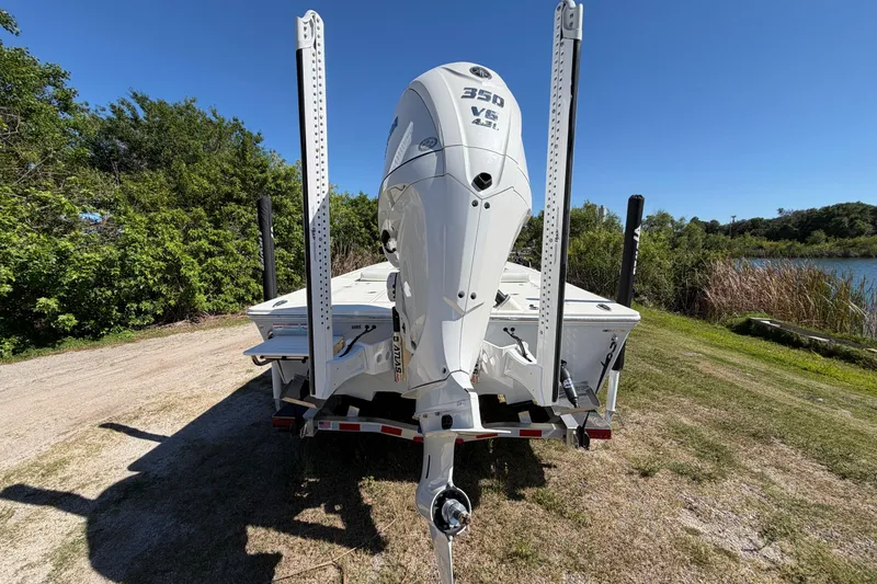 Slide: The Image of 2026 Hewes Redfisher 21 boat with powerful 350 V8 engine, parked near a scenic lake. - 8