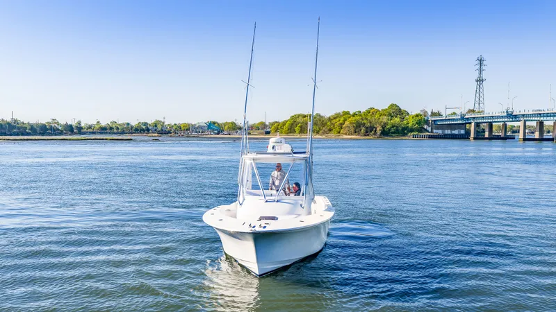 Slide: The Image of 2005 L&H Walkaround boat on calm water near bridge. - 11