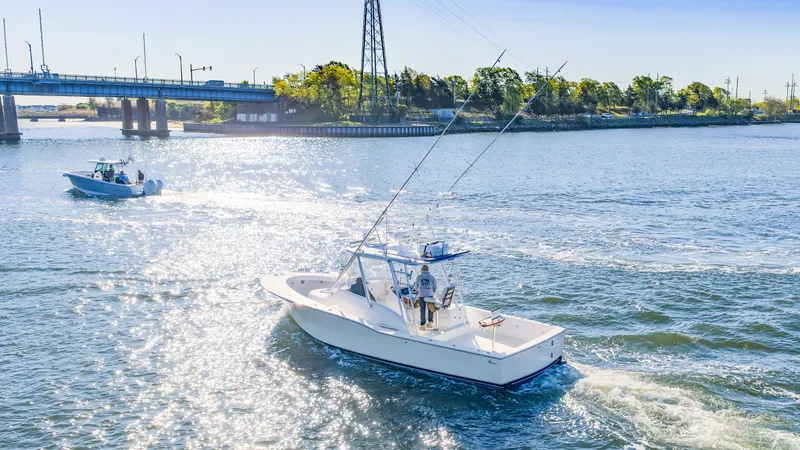 Slide: The Image of 2005 L&H Walkaround boat on sunny river with bridge. - 18