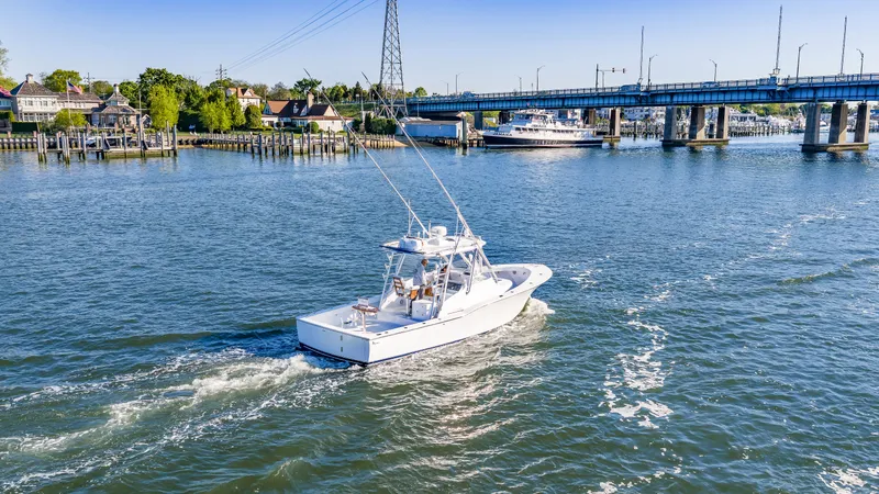 Slide: The Image of 2005 L&H Walkaround boat cruising on a river under a bridge. - 20