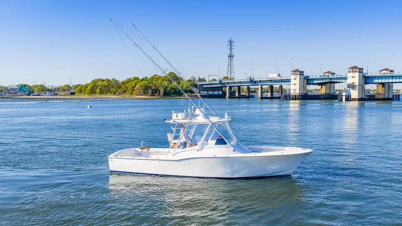 Slide: The Image of 2005 L&H Walkaround boat on calm water near a bridge. - 7