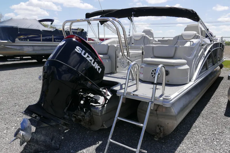 Slide: The Image of 2018 Sylvan S-3 pontoon boat with Suzuki outboard motor, parked on gravel lot. - 16