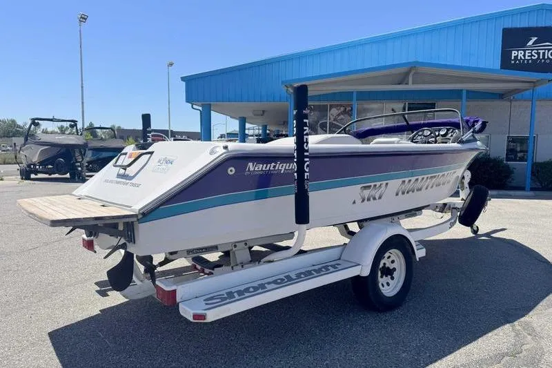 Slide: The Image of 1995 Correct Craft Ski Nautique boat on trailer outside Prestige Water Sports building. - 12