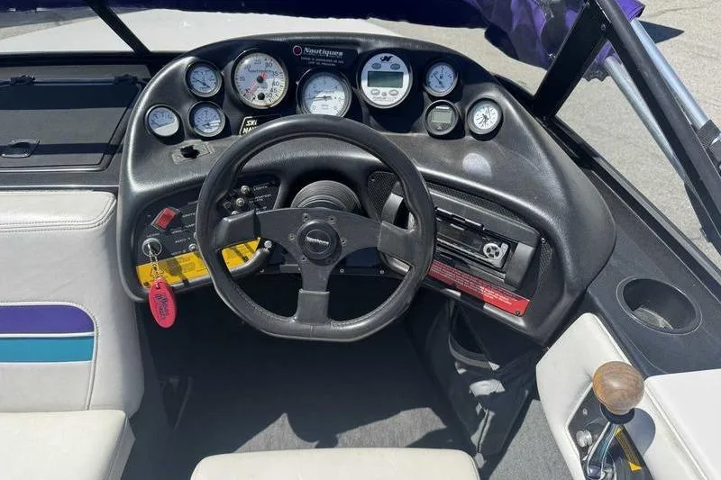 Slide: The Image of 1995 Correct Craft Ski Nautique dashboard with steering wheel and instrument gauges. - 15
