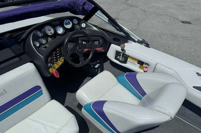 Slide: The Image of 1995 Correct Craft Ski Nautique boat interior with dashboard and white seats. - 7