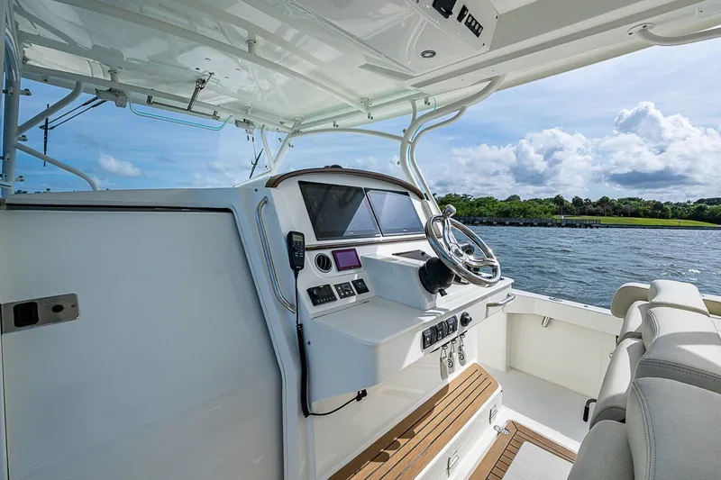 Slide: The Image of 2019 Hinckley Sport Boat 40 C cockpit with modern controls, steering wheel, and waterfront view. - 13