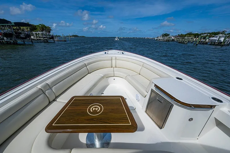 Slide: The Image of 2019 Hinckley Sport Boat 40 C with elegant seating and wooden table on open water. - 16