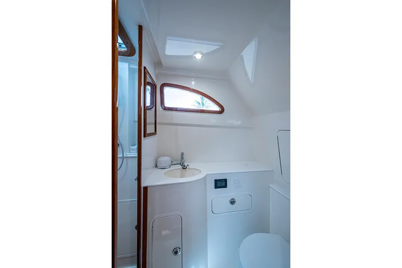 Slide: The Image of Hinckley Sport Boat 40 C 2019 bathroom interior with sink, mirror, and wooden accents. - 24