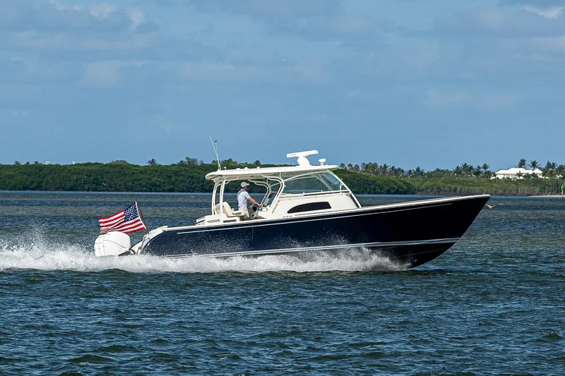 Slide: The Image of 2019 Hinckley Sport Boat 40 C cruising on open water with American flag. - 4