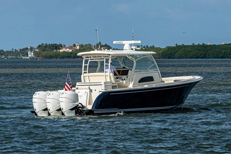 Slide: The Image of 2019 Hinckley Sport Boat 40 C cruising on open water with triple outboard engines. - 5