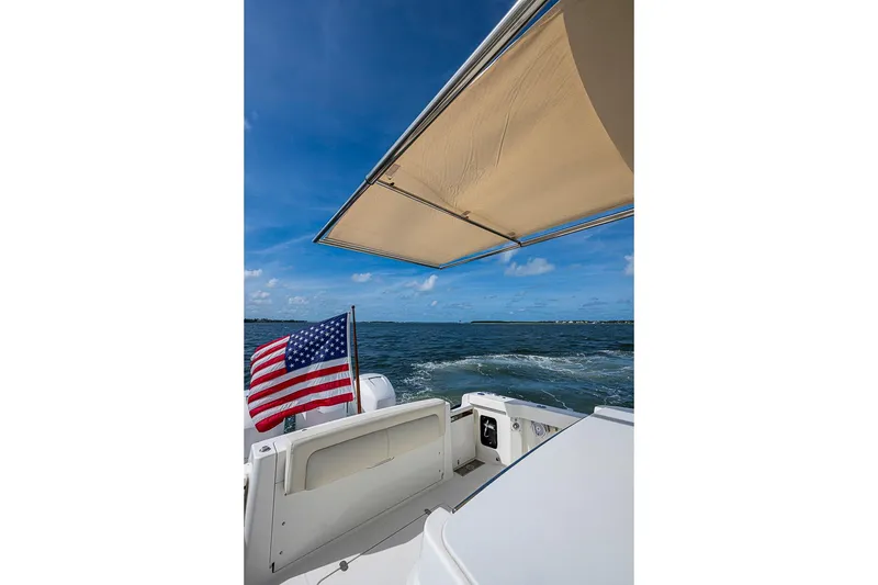 Slide: The Image of 2019 Hinckley Sport Boat 40 C cruising with American flag and sunshade. - 6