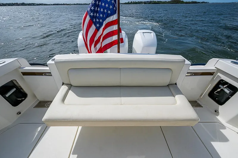 Slide: The Image of 2019 Hinckley Sport Boat 40 C with American flag, rear seating, and ocean view. - 8