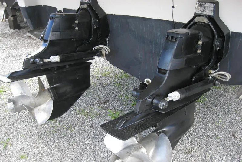 Slide: The Image of 2010 Crownline 330 CR boat propellers and outdrives on gravel surface. - 10