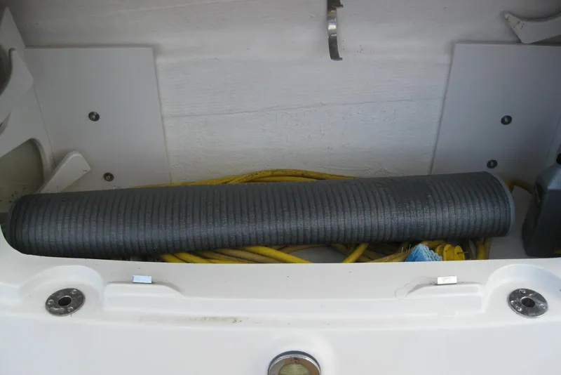 Slide: The Image of Storage compartment with hose and cables on a 2010 Crownline 330 CR boat. - 12