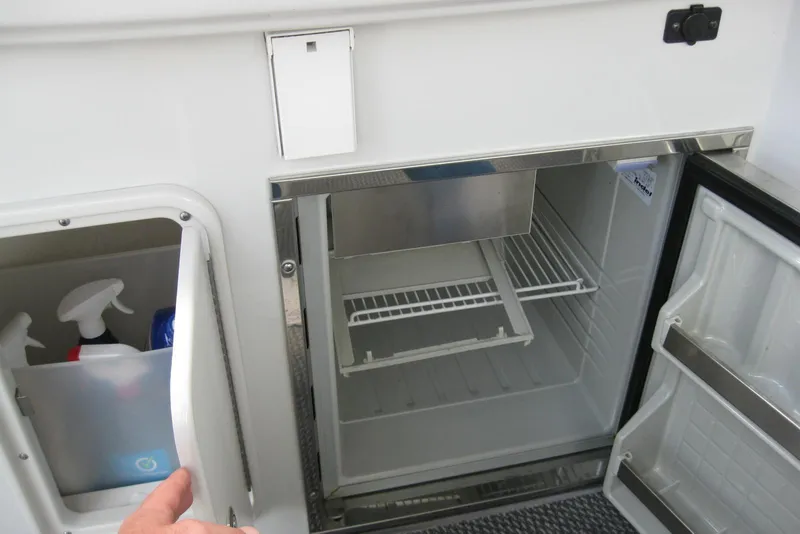 Slide: The Image of Open refrigerator and storage compartment on a 2010 Crownline 330 CR boat. - 16