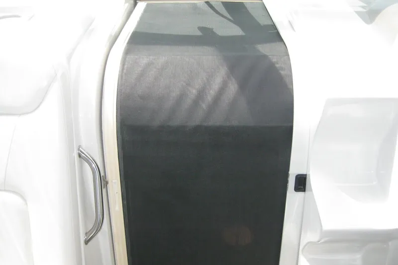 Slide: The Image of 2010 Crownline 330 CR boat interior with black mesh door and white seating. - 26