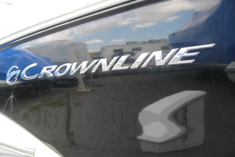 Slide: The Image of Crownline 330 CR 2010 boat logo on sleek black surface. - 5