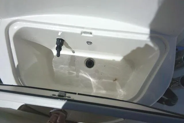 Slide: The Image of Livewell compartment in a 2021 Carolina Skiff 23 LS boat, featuring a drain and water inlet. - 15