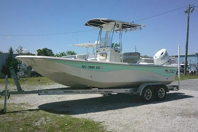 Slide: The Image of 2021 Carolina Skiff 23 LS boat on trailer, parked outdoors under clear blue sky. - 2