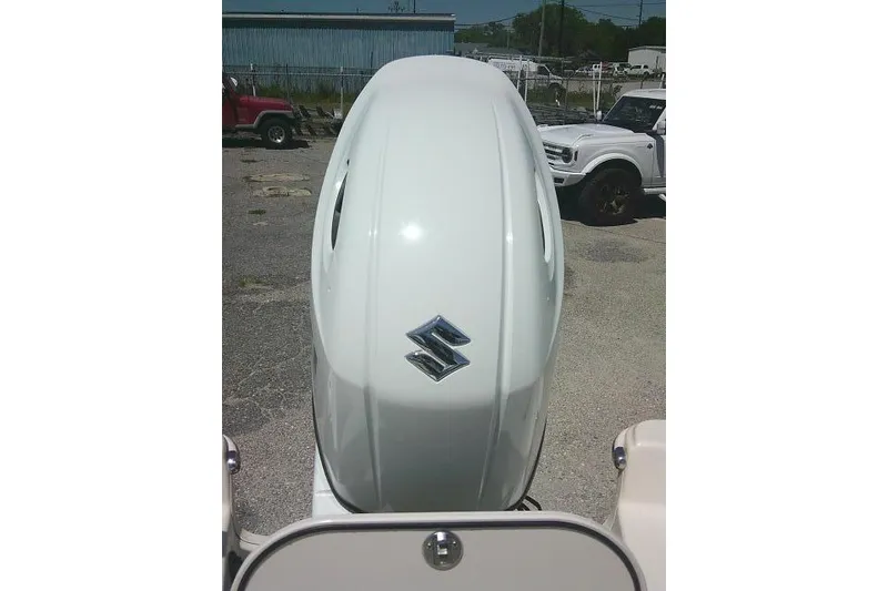 Slide: The Image of 2021 Carolina Skiff 23 LS with Suzuki outboard motor in a parking lot. - 23