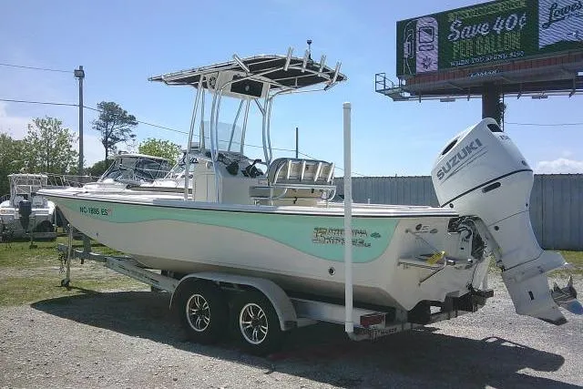 Slide: The Image of 2021 Carolina Skiff 23 LS boat on trailer with Suzuki outboard motor, parked outdoors. - 6