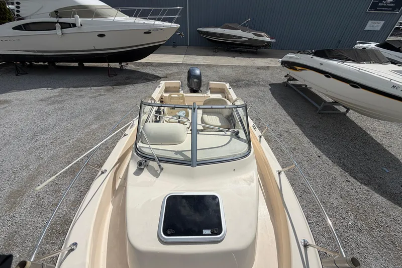 Slide: The Image of 2011 Grady-White Adventure 208 boat in storage, surrounded by other vessels. - 17
