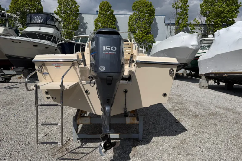 Slide: The Image of 2011 Grady-White Adventure 208 boat with Yamaha 150 four-stroke engine in a marina. - 2