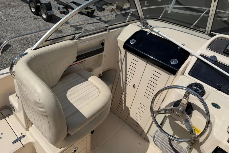 Slide: The Image of 2011 Grady-White Adventure 208 boat cockpit with steering wheel and beige seating. - 6