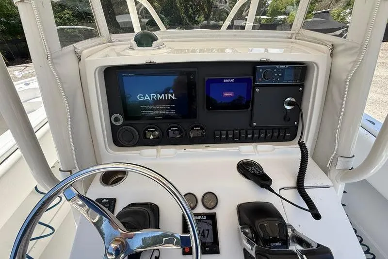 Slide: The Image of 2003 Jupiter 31 Cuddy boat dashboard with Garmin navigation system and steering wheel. - 24