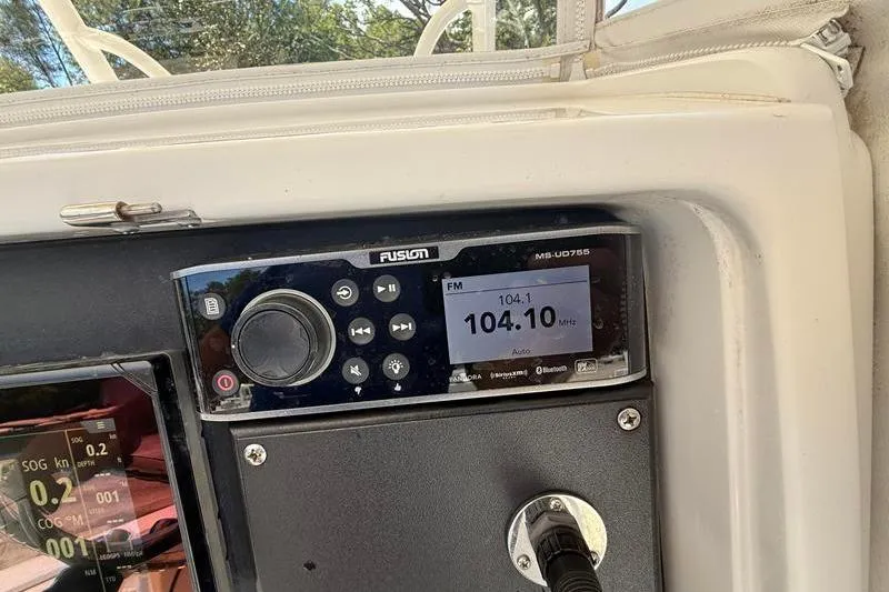 Slide: The Image of Fusion marine radio on a 2003 Jupiter 31 Cuddy, tuned to 104.1 FM. - 27