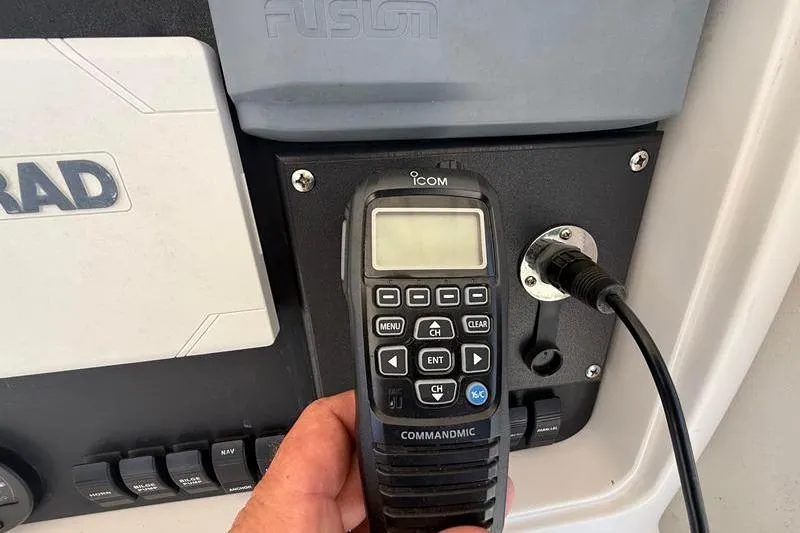 Slide: The Image of Hand holding Icom CommandMic on 2003 Jupiter 31 Cuddy boat dashboard. - 30