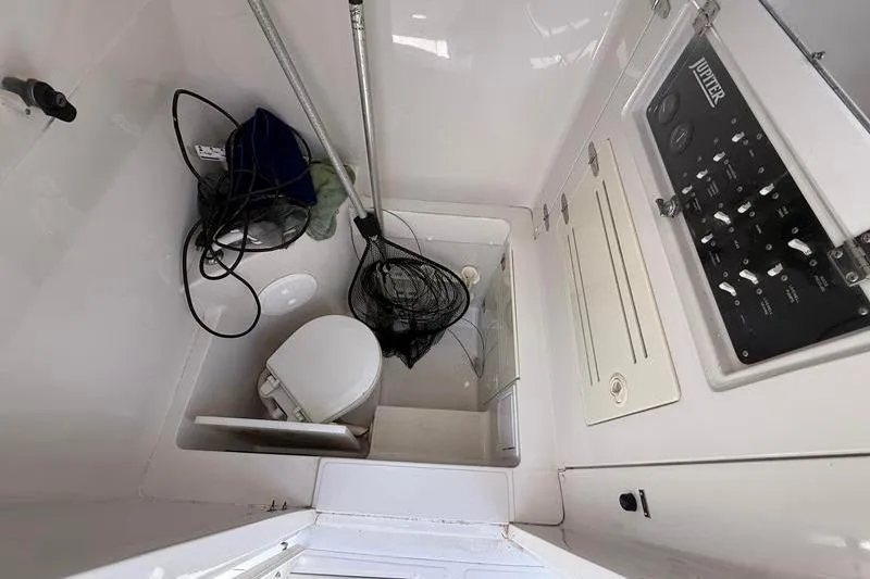 Slide: The Image of Interior of a 2003 Jupiter 31 Cuddy boat showing a compact bathroom setup. - 31