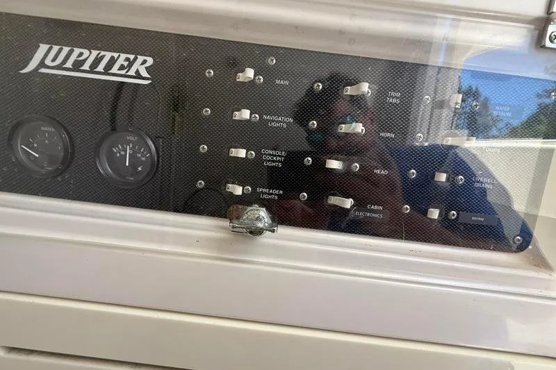 Slide: The Image of Control panel of a 2003 Jupiter 31 Cuddy boat with switches and gauges. - 32