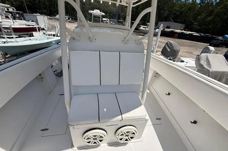 Slide: The Image of 2003 Jupiter 31 Cuddy boat interior with white seating and dual speakers. - 36