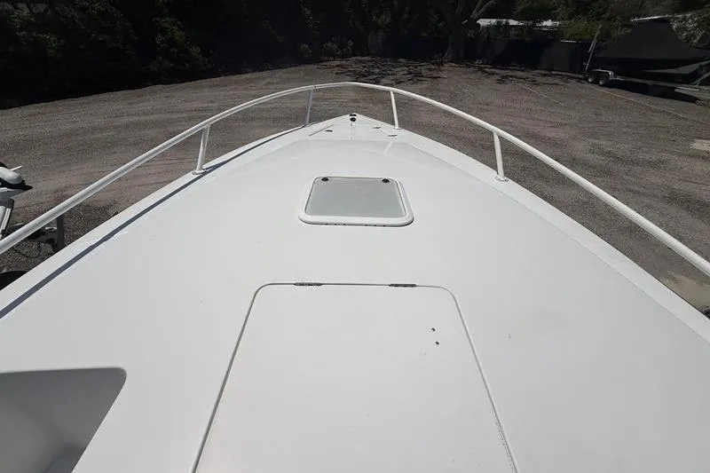 Slide: The Image of 2003 Jupiter 31 Cuddy boat deck with hatch, parked on gravel. - 37
