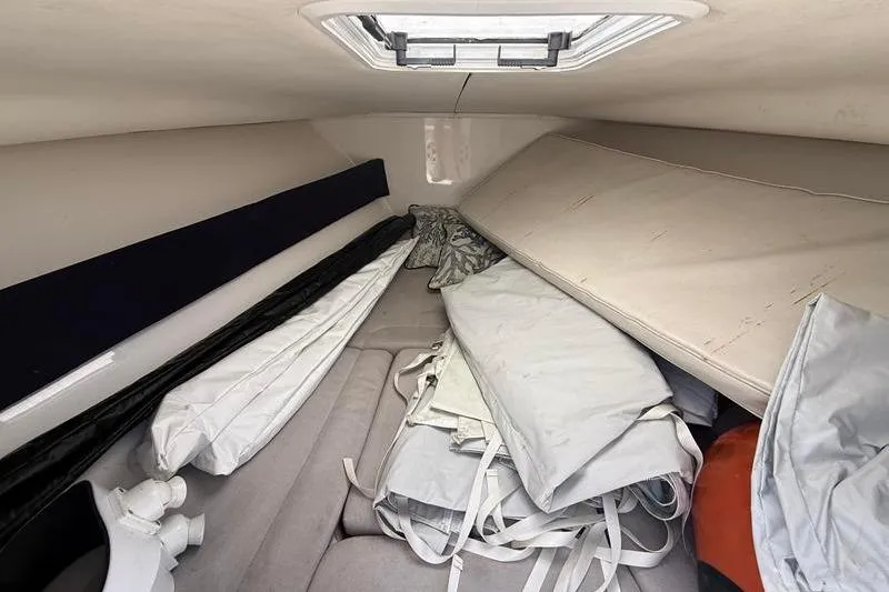 Slide: The Image of Interior of a 2003 Jupiter 31 Cuddy boat with stored cushions and equipment. - 40