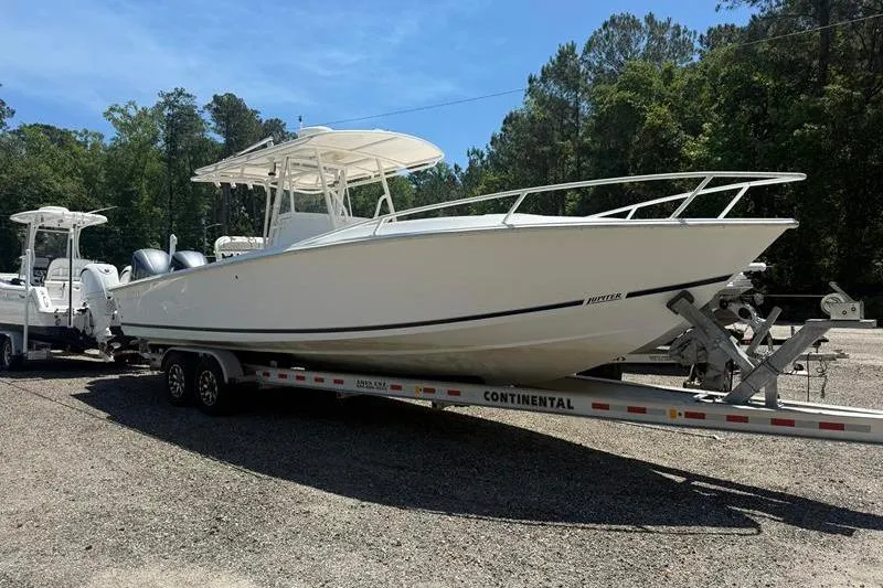Slide: The Image of 2003 Jupiter 31 Cuddy boat on trailer, parked outdoors under clear sky. - 9