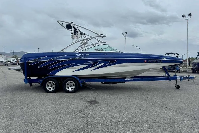 Slide: The Image of Blue 2007 MB TOMCAT boat on trailer, parked in a lot under cloudy skies. - 13