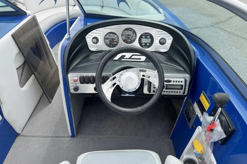 Slide: The Image of 2007 MB TOMCAT boat dashboard with steering wheel, gauges, and controls in a blue interior. - 21