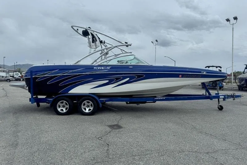 Slide: The Image of 2007 MB TOMCAT boat on trailer, blue and white design, parked outdoors. - 6