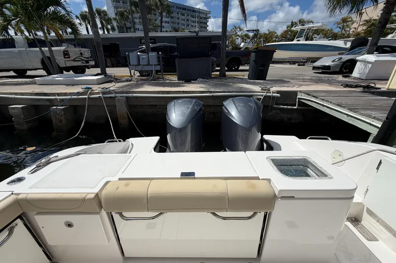 Slide: The Image of 2018 Pursuit OS 355 Offshore boat docked, featuring dual outboard motors and a spacious deck. - 13